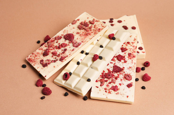White chocolate bars with freeze dried fruits on beige background - Φωτογραφία, εικόνα