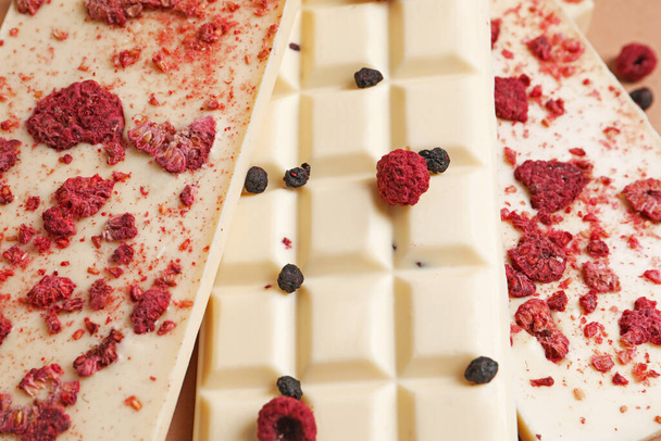 White chocolate bars with freeze dried fruits as background, closeup - 写真・画像