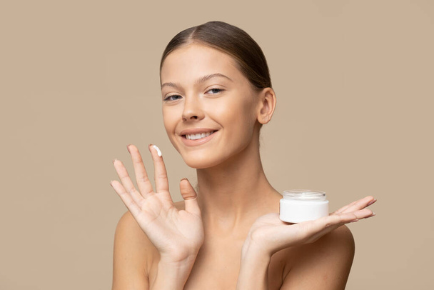 Young girl is apply face cream. - Photo, Image
