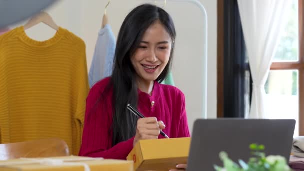 Startup small business entrepreneur of freelance Asian woman using a laptop with box Cheerful success online marketing packaging box and delivery SME idea concept. - Footage, Video