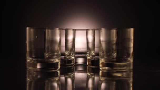 Ice falls into an empty glass. The glasses move out of the frame. - Footage, Video
