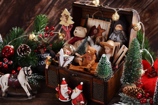 Vintage style Christmas toys and decors in old wooden chest on the table - Photo, image