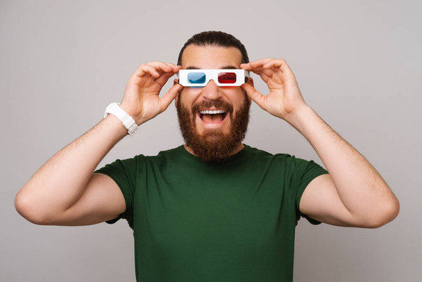 niesamowite młody przystojny brodaty mężczyzna noszenie okulary 3D na szare tło - Zdjęcie, obraz