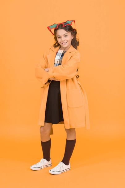 Enjoy confidence. Confident school child yellow background. Happy girl with confident smile. Small kid wear party glasses with confident look. Smart and confident. - Φωτογραφία, εικόνα
