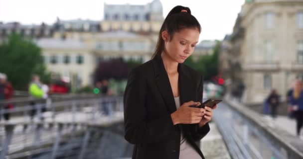 Mulher de negócios bonita em Paris mensagens com telefone celular na rua da cidade. Sério feminino bem sucedido em viagem de negócios colega de mensagens. 4k - Filmagem, Vídeo