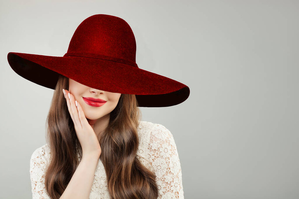 Jonge vrouw met brede hoed. Mooi model met rode lippen make-up en leuke glimlach portret - Foto, afbeelding