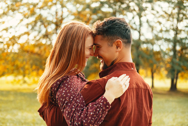 若い素敵なカップルは緑の公園で一緒に笑って楽しい時間を過ごしています。彼らはちょうど良いニュースを受け取った. - 写真・画像
