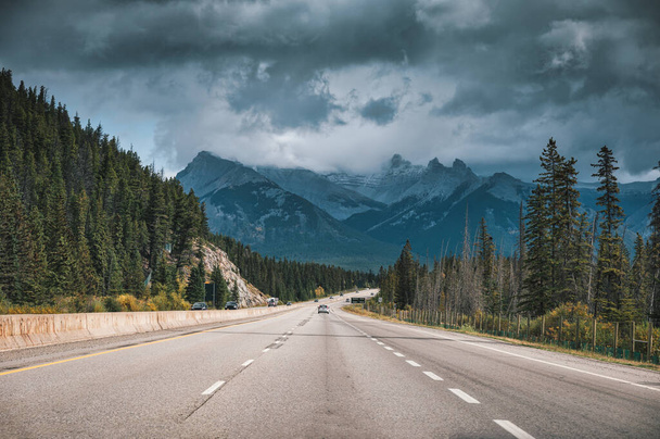 Scenic road on highway and moody sky in Canadian Rockies at Banff national park, AB, Canada - 写真・画像