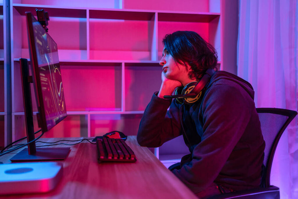 Handsome boy playing E-Sport game or streamer, Defeat or failure, Mistakes of managing a team in the game lead to defeat,  Live show play games, Blue and red lights. - Fotoğraf, Görsel