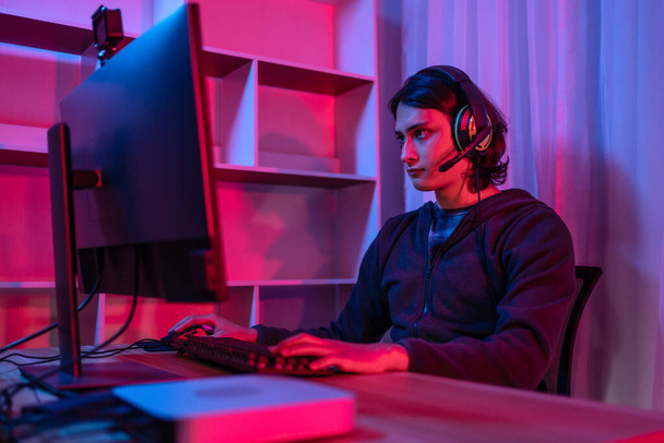 Handsome boy playing E-Sport game or streamer, Enjoying playing online games, Entertainment  or technology game trends, Live show play games, Focus monitor, Blue and red lights. - Fotó, kép