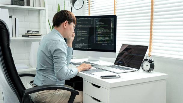 Male programmer is programming to develop program app and website of corporate while working to checking program code and debugging on multiple screen at modern software office. - Foto, immagini