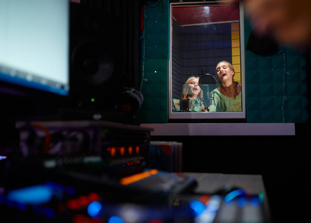 Zespół dziecięcy śpiewający w studio nagraniowym, nastoletni muzycy nagrywający muzykę selektywne skupienie - Zdjęcie, obraz