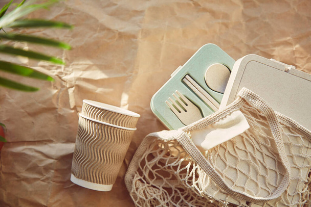 Χωρίς πλαστικά, φιλικά προς το περιβάλλον οικολογικά πιάτα σε επαναχρησιμοποιήσιμη σακούλα σε τσαλακωμένο χαρτί. Βιώσιμος τρόπος ζωής. - Φωτογραφία, εικόνα