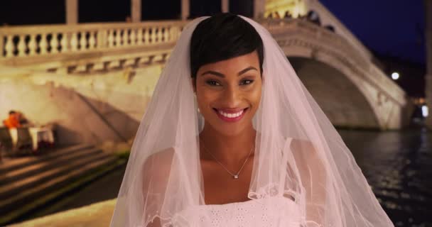 Porträt einer glücklich errötenden Braut am Canal Grande bei Nacht, aufgeregt und schön. Schwarze Frau aufgeregt in Venedig, Italien zu heiraten. 4k - Filmmaterial, Video