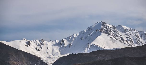 Panorama de una cordillera con picos montañosos con nieve y glaciares, un día nublado de otoño en el Cáucaso - Foto, imagen