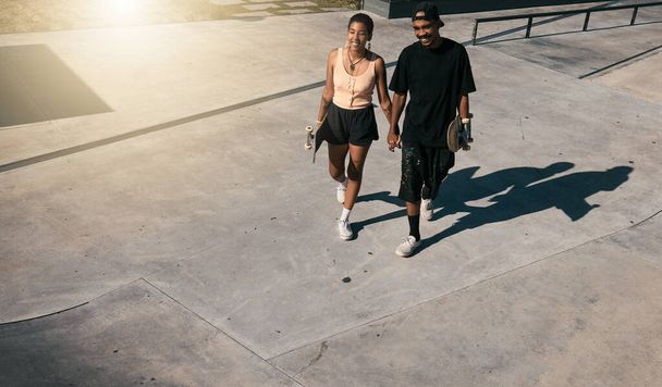 Couple, holding hands or walking on skatepark date in fun fitness, skating exercise or love bonding. Smile, happy man or skater woman and skateboard, edgy or fashion clothes in Brazilian summer break. - 写真・画像