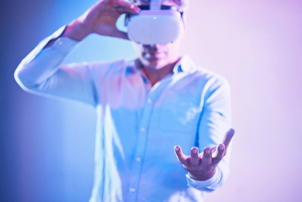 Metaverse Headset, Virtual Reality und Mann Hand hält Cyber-Welt ai, digitale Transformation und abstrakten Raum in Handflächen. Vr, futuristische Technologie und Innovationssoftware auf Neon-Studiohintergrund. - Foto, Bild