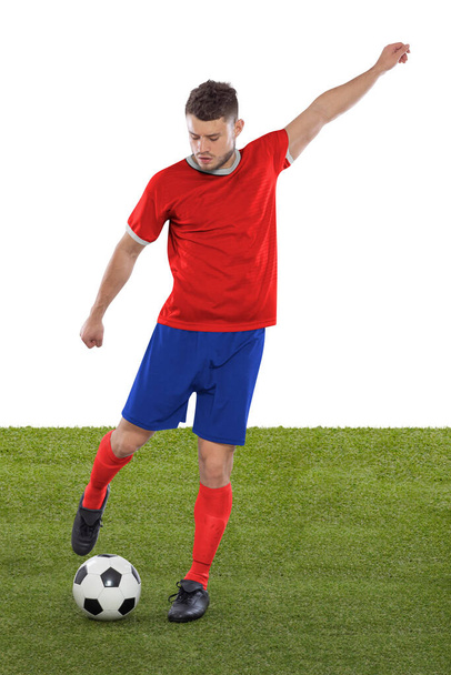 Giocatore di calcio professionista con maglia rossa della nazionale del Costa Rica sul punto di segnare un gol con un'espressione di sfida e decisione sul suo volto su sfondo bianco. - Foto, immagini