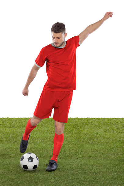 Professional soccer player with red Canada national team jersey about to score a goal with an expression of challenge and decision on his face on white background. - Foto, imagen