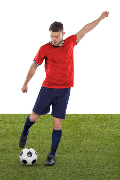 Professional soccer player with red Spain national team jersey about to score a goal with an expression of challenge and decision on his face on white background. - Foto, imagen