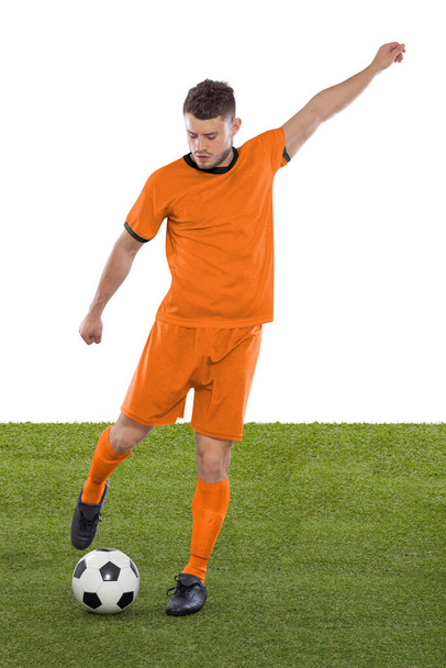 Professional soccer player with orange Netherlands national team jersey about to score a goal with an expression of challenge and decision on his face on white background. - Foto, Imagem