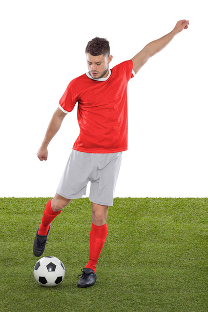 Professional soccer player with red Switzerland national team jersey about to score a goal with an expression of challenge and decision on his face on white background. - Foto, immagini