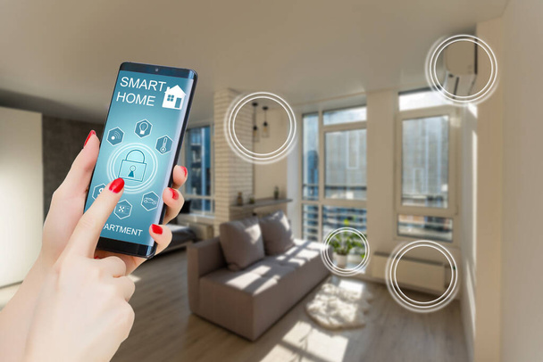 スマートホーム、携帯電話上のクローズアップで家庭用暖房温度を制御します。自宅でスマートデバイスを管理するためのスマートホームとモバイルアプリケーションの概念. - 写真・画像