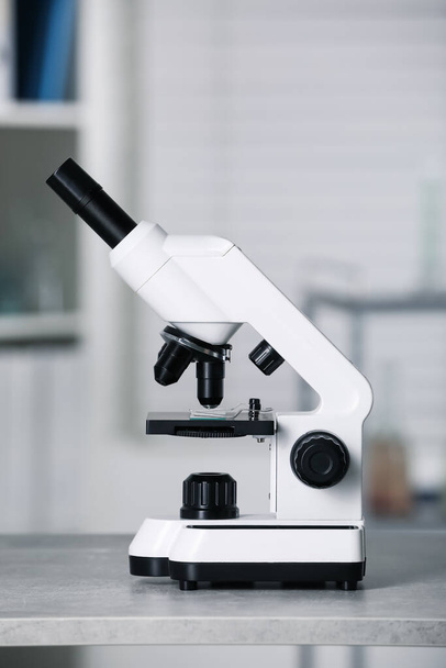 Modern medical microscope on grey table in laboratory - 写真・画像