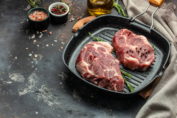 Raw fresh meat steaks on frying pan on a dark background. banner, menu, recipe place for text, top view, - Φωτογραφία, εικόνα