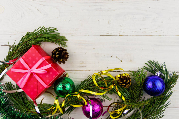 Рождественская композиция с ветками елки, подарочной коробкой и рождественскими украшениями на белом деревянном столе. Вид сверху, пространство для копирования - Фото, изображение