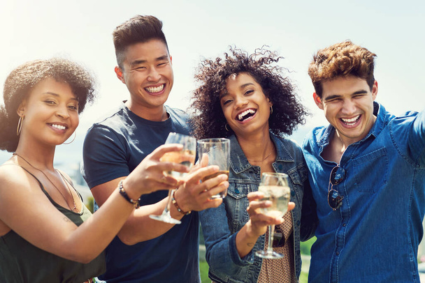 Salud a todos. Retrato de un grupo de amigos tomando algo y compartiendo un brindis al aire libre mientras están de vacaciones - Foto, imagen