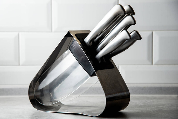 sada 5 kuchyňských nožů ve stojanu stojí na stole - Fotografie, Obrázek