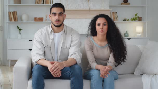 Portré komoly nyugodt magabiztos sértett nyugodt házas pár multiracionális változatos nő és férfi spanyol indiai srác és kaukázusi latin hölgy ül az új otthon kanapén nézi kamera válás - Felvétel, videó