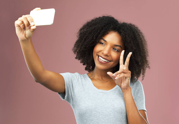 Itseluottamus sanoo, ota selfie. Studio laukaus houkutteleva nuori nainen ottaa selfie pinkkiä taustaa vasten - Valokuva, kuva