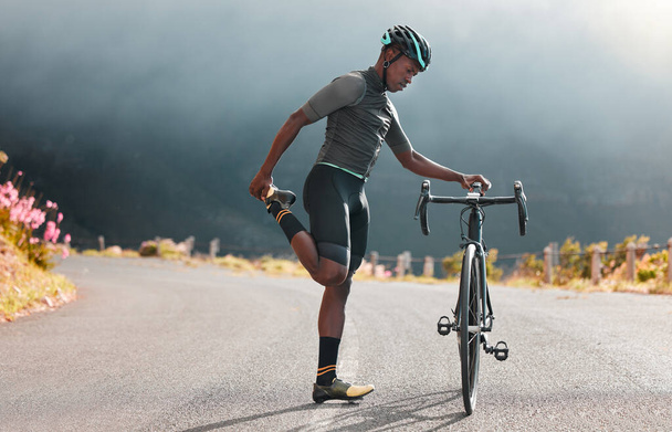 黒人男性、道路や自転車のストレッチ、フィットネスやマラソントレーニング、トライアスロンスポーツや屋外サイクリングワークアウト。マウンテンバイク選手は体を暖め、心臓のパフォーマンスとバランスの焦点. - 写真・画像
