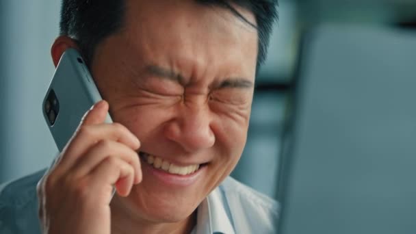幸せな感情的なビジネスマン労働者アジア系中国人日本人男性の会社の創設者笑顔大人の男性の仕事でオフィストーク携帯電話5g接続遠くの携帯電話電話によるビジネス相談 - 映像、動画