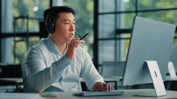 Επαγγελματίας σύμβουλος επιχειρήσεων προπονητής επιχειρηματίας εκπαιδευτικός ασιατικός κορεάτης άνδρας χρήση ακουστικών μιλούν σε απευθείας σύνδεση με τους συναδέλφους από το βίντεο chat μακρινό συνέδριο εργασίας στο επάγγελμα telemarketing γραφείων - Πλάνα, βίντεο