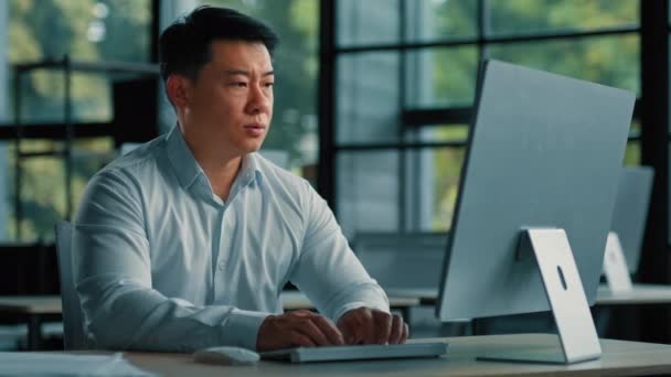 Tired exhausted businessman asian chinese middle-aged man work online in office feel headache pain fatigue after overwork with computer massaging head temples unwell health problem mental depression - Footage, Video