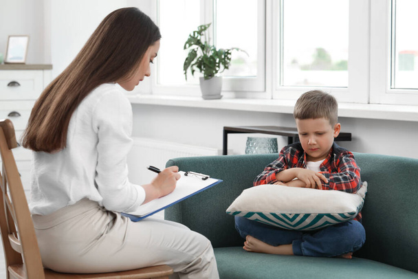 Psychologist working with unhappy little boy in office. Mental health problems - Photo, Image