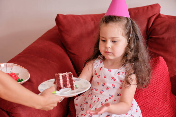 little girl in a cute dress and party hats at her brother's birthday celebration - Foto, imagen