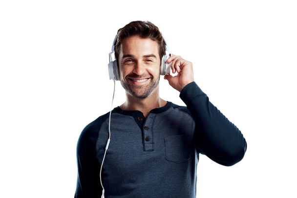 One on one time with my favourite musician. Studio portrait of a handsome young man using headphones against a white background - Photo, Image