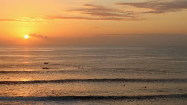 Pôr do sol incrível na praia de Uluwatu, onde surfistas e pescadores se encontram no mar ao entardecer, Uluwatu, Bali, Indonésia. - Foto, Imagem