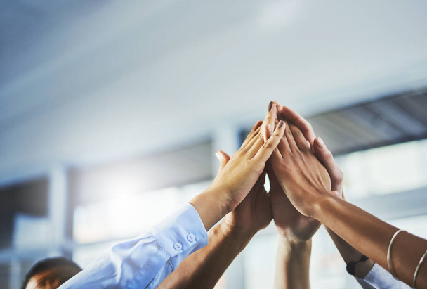 Success is what were aiming for. Closeup shot of a group of businesspeople high fiving each other in an office - Foto, imagen