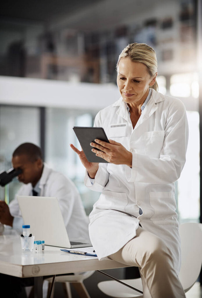 Theyre in the business of scientific discoveries. an attractive mature female scientist using a tablet while doing research in her lab - Photo, Image