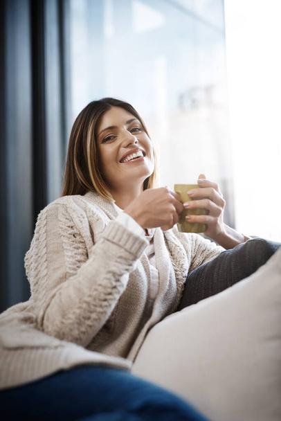 Enjoying coffee and my own company. a young woman enjoying a cup of coffee while relaxing at home - Fotoğraf, Görsel