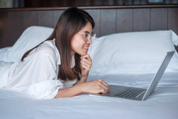 Happy nő használja laptop a munka, női találkozó online számítógép notebook az ágyban. technológia, hálózat, otthoni munka, életmód és digitális kommunikációs koncepció - Fotó, kép