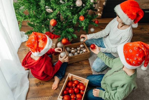 Crianças irmãos e irmã estão se preparando para as férias e decorar a árvore de Ano Novo com bolas de Natal. As crianças estão esperando o Ano Novo e o Natal - Foto, Imagem