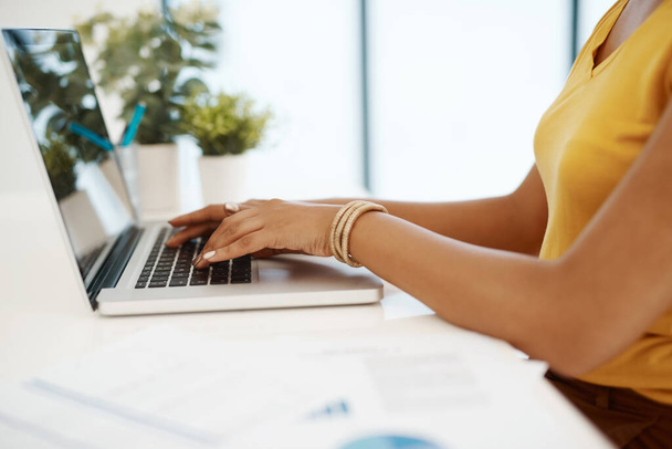 Colocar as mãos na produtividade. uma mulher de negócios usando um laptop em sua mesa em um escritório moderno - Foto, Imagem