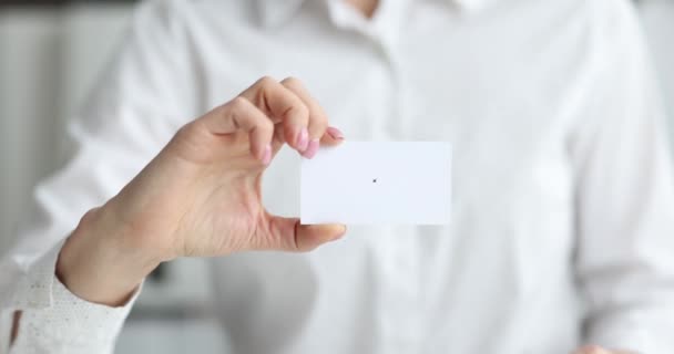 Biznesmen pokazuje białą wizytówkę na spotkaniu. Etykieta przedsiębiorstwa - Materiał filmowy, wideo
