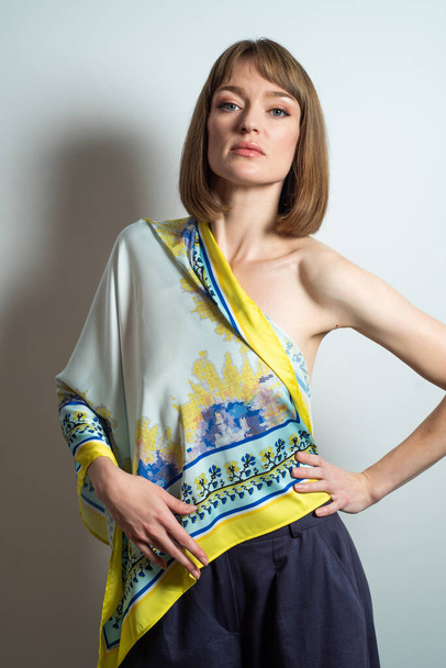portret van een mooie jonge vrouw met vlechten in modekleding. studio shot op witte achtergrond. - Foto, afbeelding
